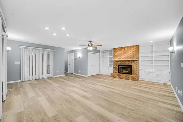 a view of empty room with wooden floor and fireplace