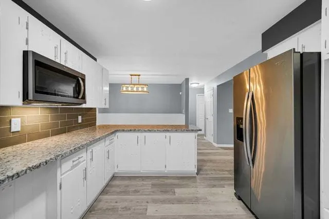 a kitchen with stainless steel appliances granite countertop a refrigerator and a sink