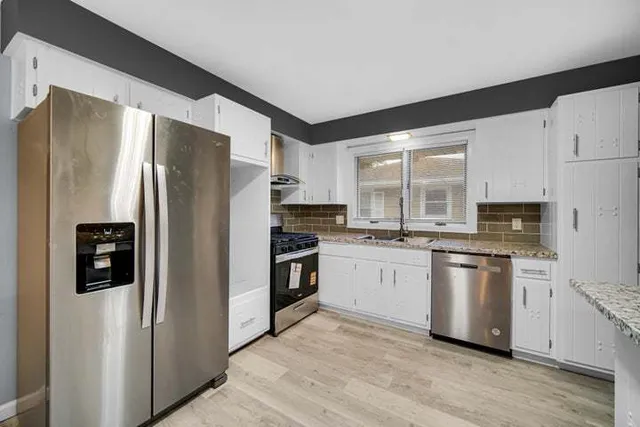 a kitchen with stainless steel appliances a refrigerator sink and microwave