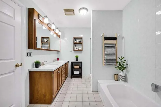 a bathroom with a sink a bathtub and a mirror