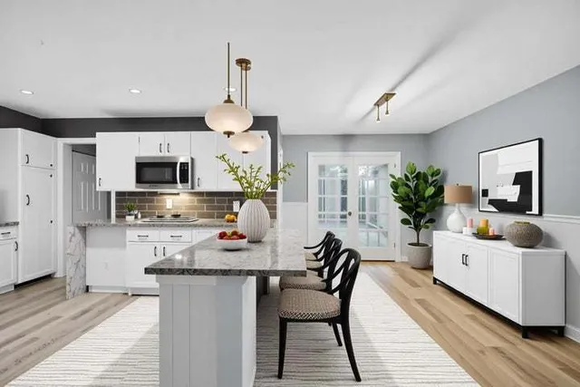 a dining room with kitchen island furniture a chandelier and kitchen view