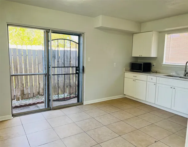 a view of a hallway with wooden floor and a bathroom