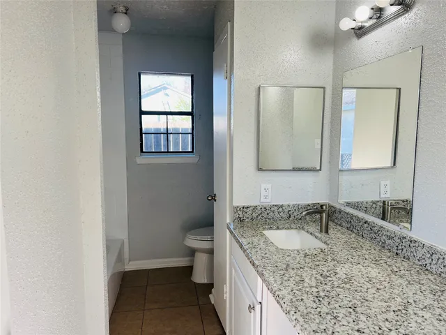 a white toilet sitting next to a bath tub