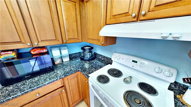a kitchen with a sink a stove and a microwave