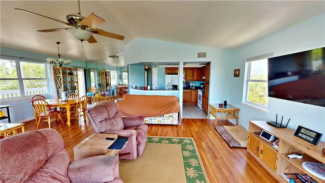 a living room with furniture a flat screen tv and a dining table