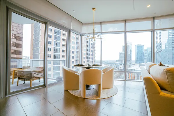 a dining room with glass top table and chairs