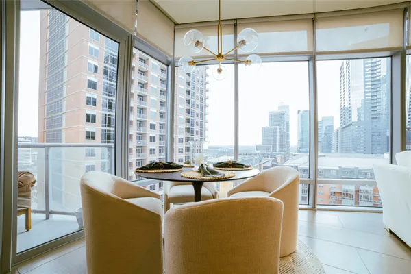 a dining room with furniture and large windows