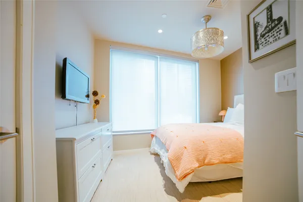 a bedroom with a bed and a chandelier