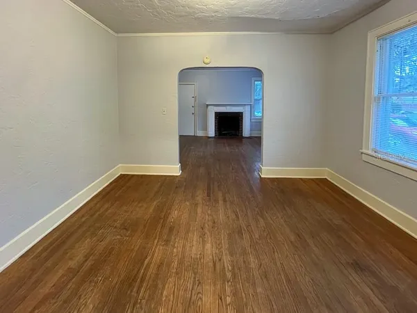 a view of empty room with wooden floor and fireplace