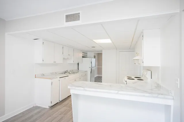 a kitchen with stainless steel appliances a sink a stove a refrigerator and cabinets