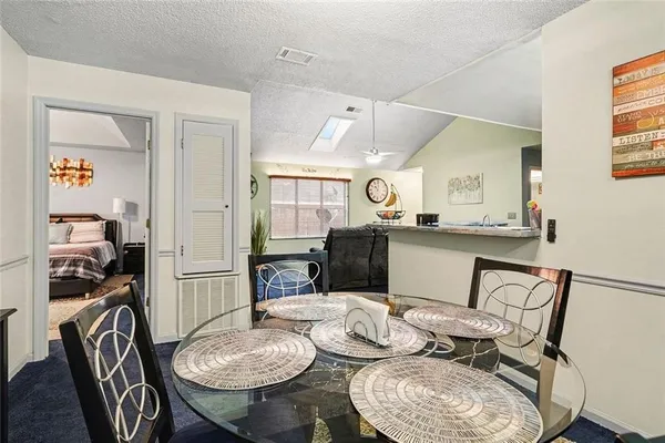 a kitchen with stainless steel appliances kitchen island granite countertop a stove a sink a dining table and chairs