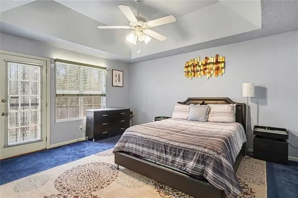 a bedroom with a bed and a large window with wooden floor