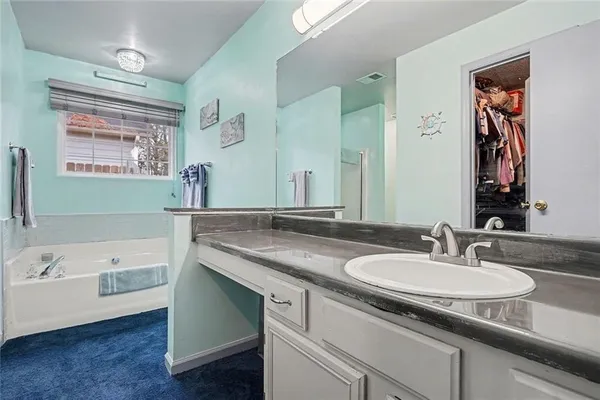 a bathroom with a granite countertop sink and a large mirror