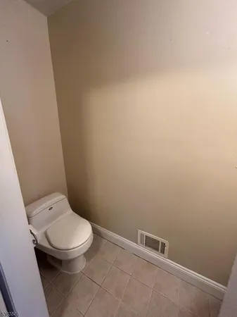 a white toilet sitting next to a white wall