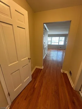 a view of a room with wooden floor and a window