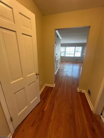 a view of a room with wooden floor and a window