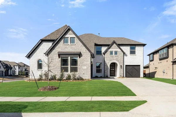 a front view of a house with a garden and plants
