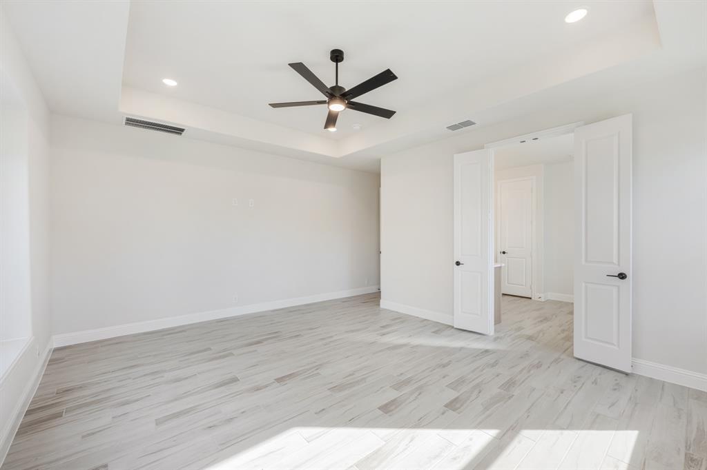 2411 Cornwall Lane Forney, TX 75126 - Photo 20 of 40 an empty room with wooden floor a ceiling fan and windows