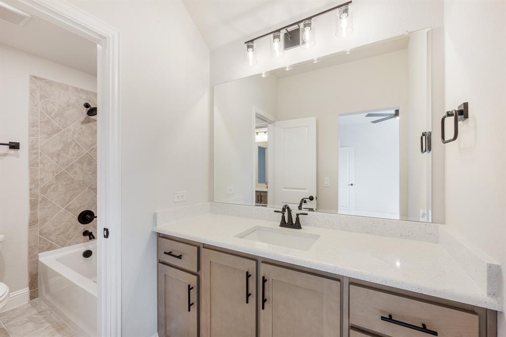 2411 Cornwall Lane Forney, TX 75126 - Photo 32 of 40 a bathroom with a tub a sink and mirror