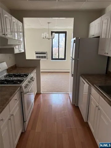 a kitchen with granite countertop a refrigerator stove and sink