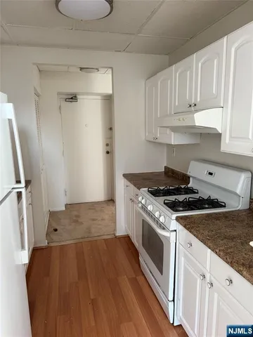 a kitchen with granite countertop a stove and a refrigerator