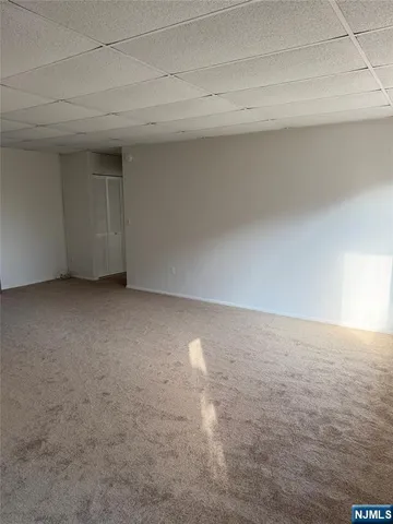 an empty room with windows and fireplace