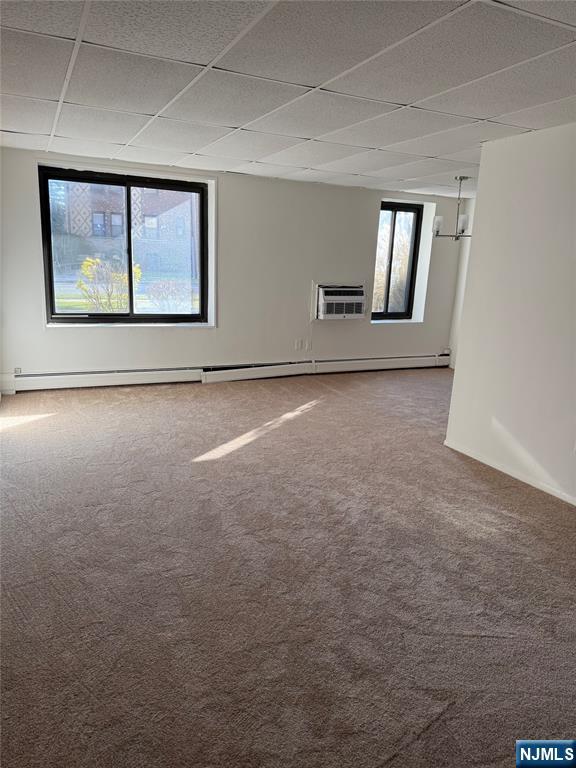 77 Prospect Avenue, Unit 1A Hackensack, NJ 07601 - Photo 6 of 10 an empty room with windows and fireplace