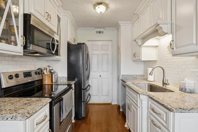 a kitchen with stainless steel appliances granite countertop a sink stove and refrigerator