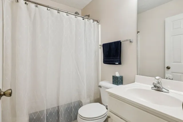 a bathroom with a toilet a sink and a mirror