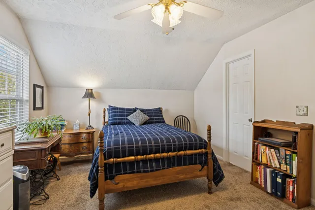 a bedroom with a bed window and a table