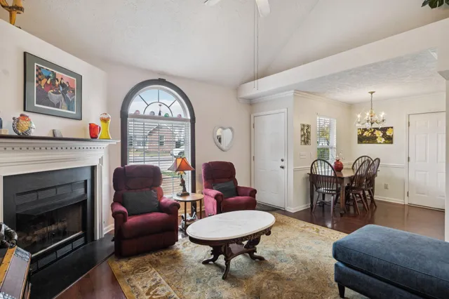 a living room with furniture a fireplace and a table