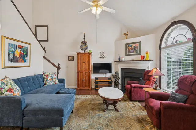 a living room with furniture a fireplace and a flat screen tv