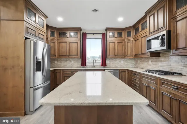 a kitchen with stainless steel appliances granite countertop a sink a stove and a refrigerator