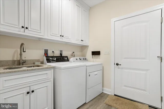 a kitchen with white cabinets and sink