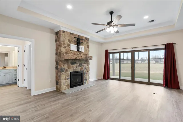 a view of an empty room with a fireplace and a window