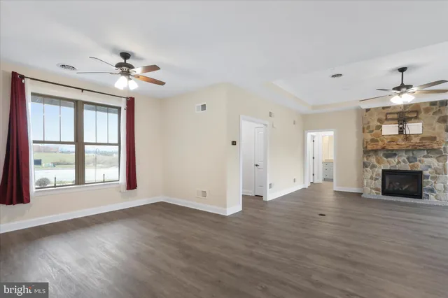 a view of an empty room with a window and fireplace