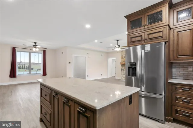 a kitchen that has a kitchen island wooden cabinets and stainless steel appliances