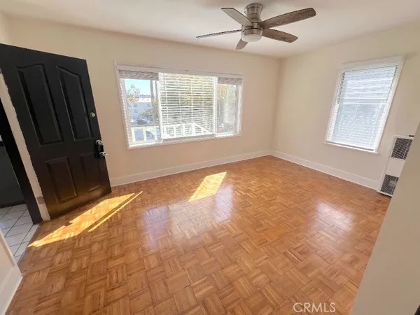 a view of an empty room with a window and a chandelier fan