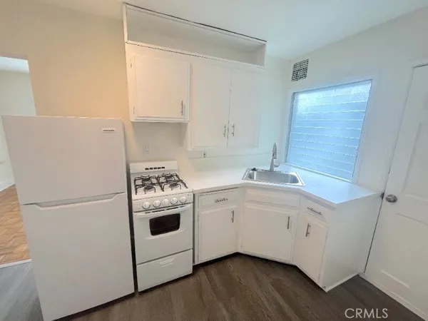 a utility room with wooden floor washer and dryer