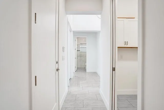 a kitchen with stainless steel appliances granite countertop a sink a stove a refrigerator cabinets and a dining table with wooden floor