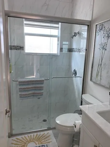 a white toilet sitting next to a shower