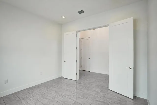 an empty room with wooden floor and ceiling fan
