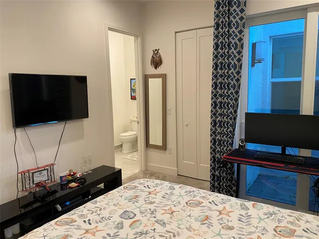 a bedroom with a bed and a flat screen tv