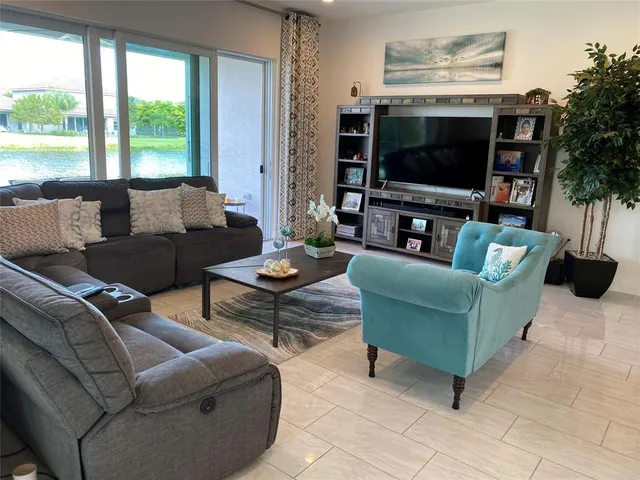 a living room with furniture a large window and a flat screen tv