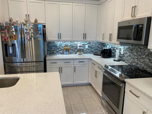 a kitchen with stainless steel appliances a stove microwave and refrigerator