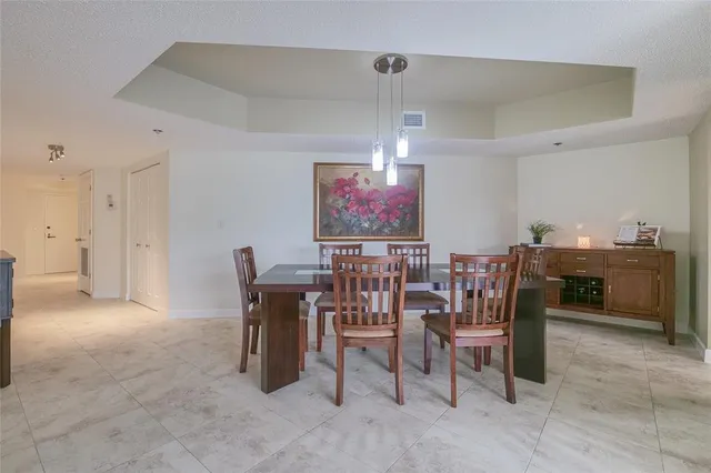 a dining room with wooden floor a chandelier a wooden table and chairs