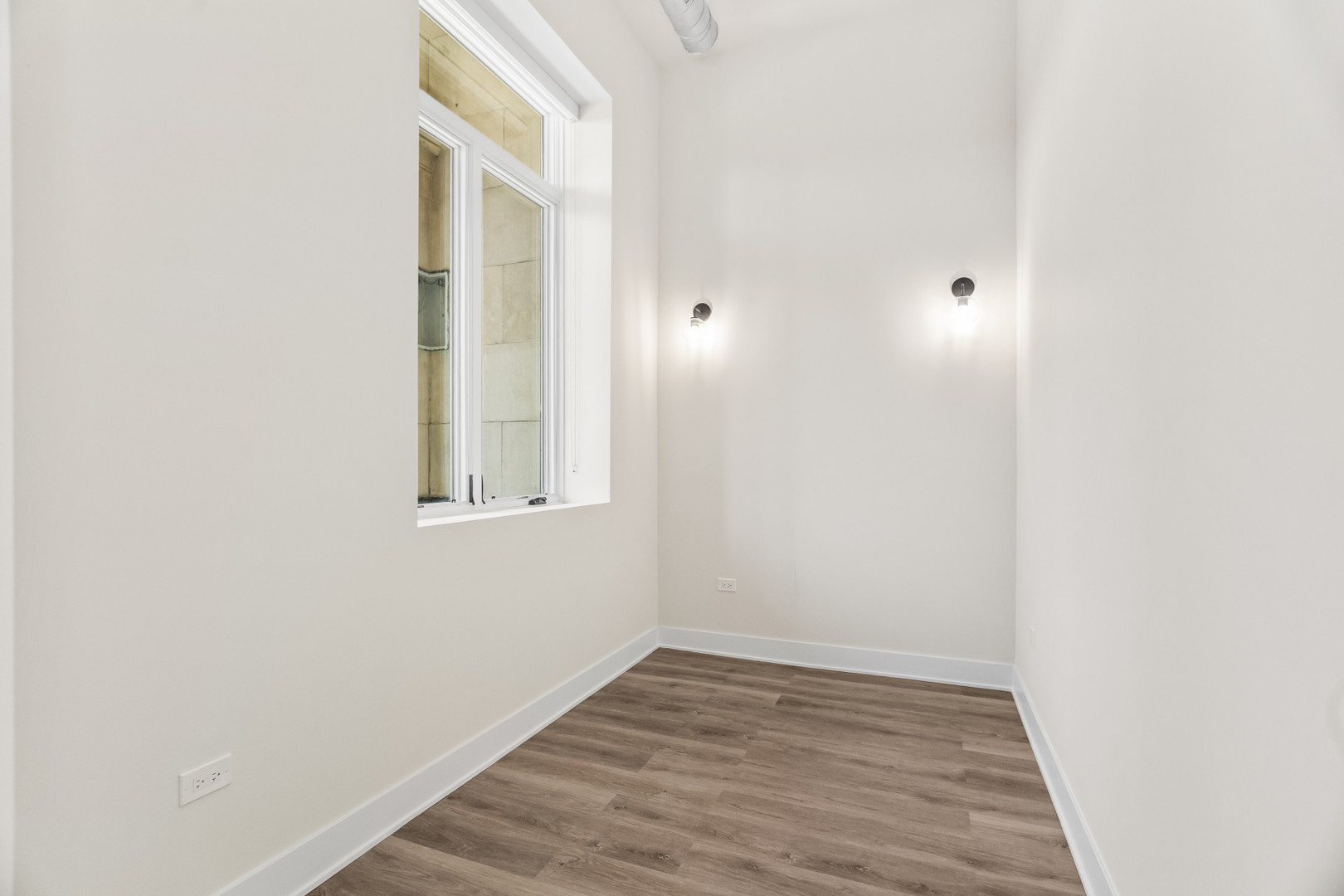 1453 Maple Avenue, Unit 201 Evanston, IL 60201 - Photo 17 of 25 a view of an empty room with wooden floor and a window