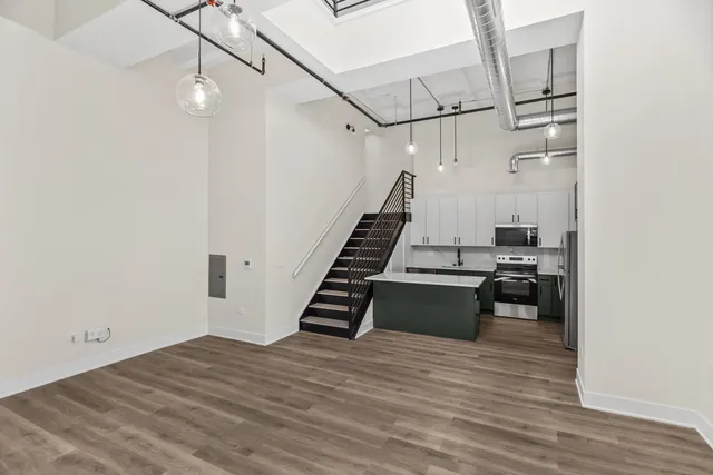 a view of a kitchen with wooden floor and electronic appliances