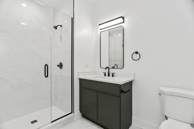 a bathroom with a toilet sink vanity and mirror