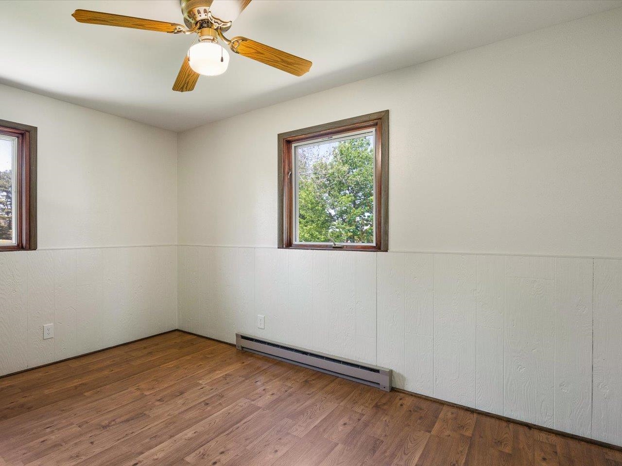 136 Lake Summerset Road Lake Summerset, IL 61019 - Photo 17 of 47 an empty room with wooden floor chandelier fan and windows